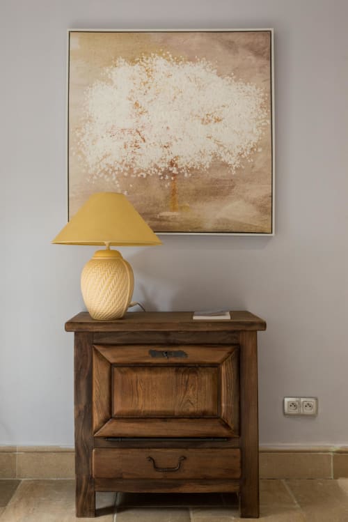Table de nuit en bois avec lampe jaune et œuvre d'art d'arbre blanc au Domaine Chapelle, La Chapelle-la-Reine