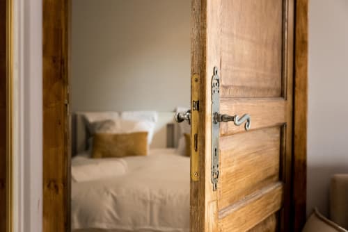 Porte en bois ouverte révélant la chambre du Domaine Chapelle B&B à La Chapelle-la-Reine, France