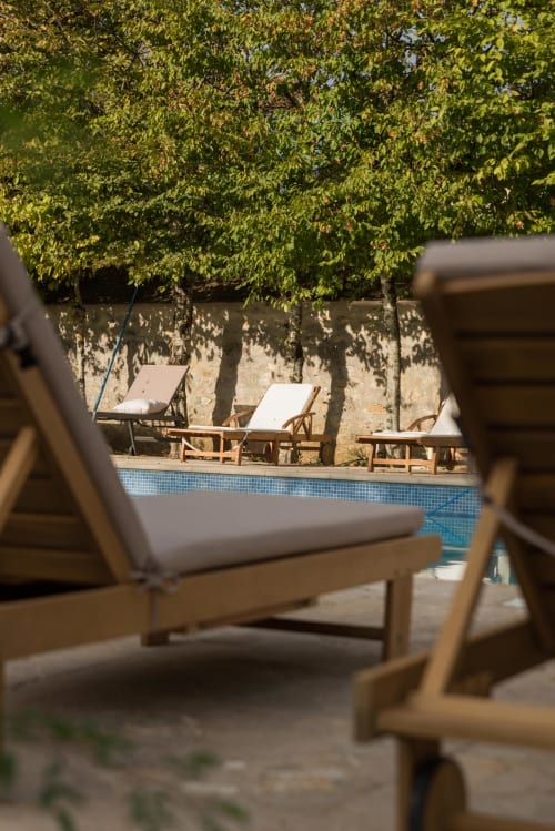 Chaises longues au bord de la piscine sous les vignes vertes du Domaine Chapelle B&B, La Chapelle-la-Reine