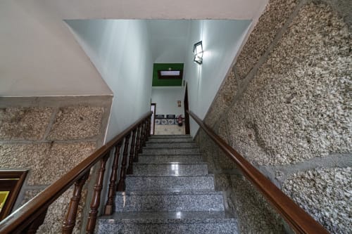Escada com corrimão de madeira na pousada Casa Augusta em Penafiel, Portugal levando aos andares superiores