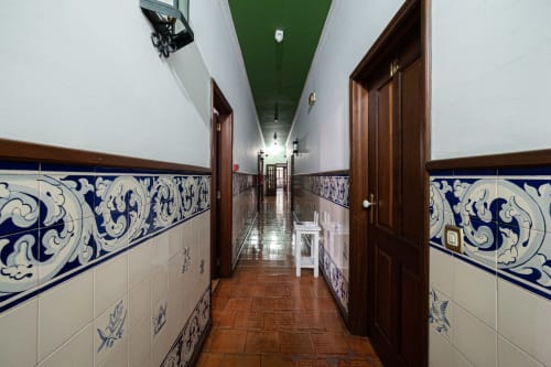Corredor comprido da pousada Casa Augusta em Penafiel com azulejos decorativos azuis e brancos e portas de madeira