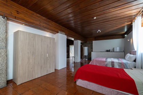 Suíte familiar espaçosa da pousada Casa Augusta em Penafiel com duas camas, teto de madeira e móveis modernos