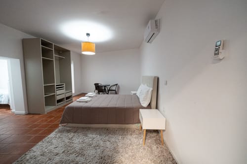 Quarto espaçoso da Casa Augusta hostel em Braga, Penafiel com cama, guarda-roupa, secretária, iluminação moderna e ar condicionado