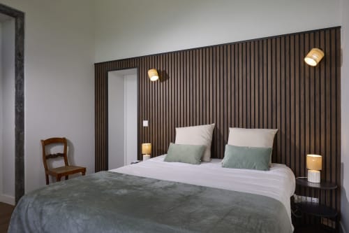 Quarto moderno em Casa Dos Barcos Furnas com parede de ripas de madeira, cama queen, almofadas verdes e iluminação contemporânea