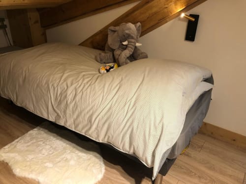 Chambre douillette aux Tanières de Montgenèvre avec peluche d'éléphant, poutres en bois et vue montagne