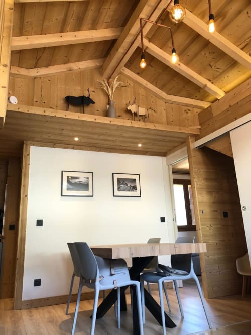 Salle à manger contemporaine de l'appartement La Frontièra aux Tanières de Montgenèvre avec poutres apparentes, luminaires suspendus et vue montagne