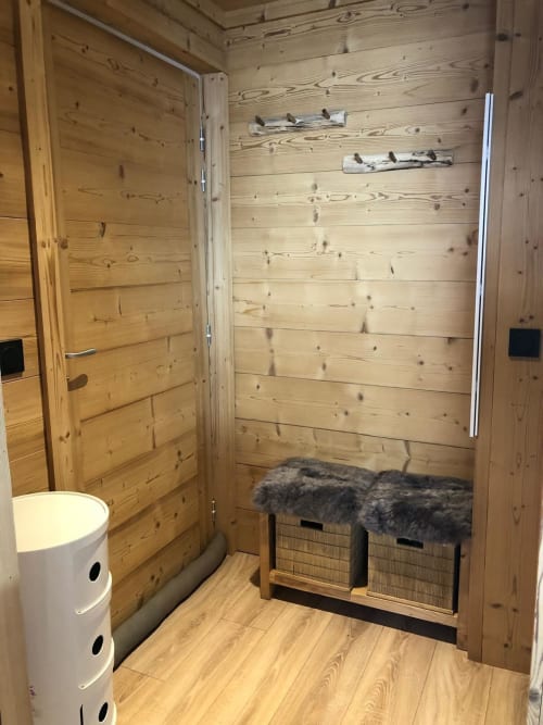 Salle de bains chaleureuse en bois aux Tanières de Montgenèvre avec paniers de rangement et sèche-serviettes électrique