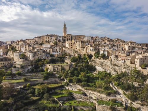 Pintoresco pueblo histórico de Xàtiva en lo alto de la colina con edificios de piedra y campanario dominando el frondoso valle