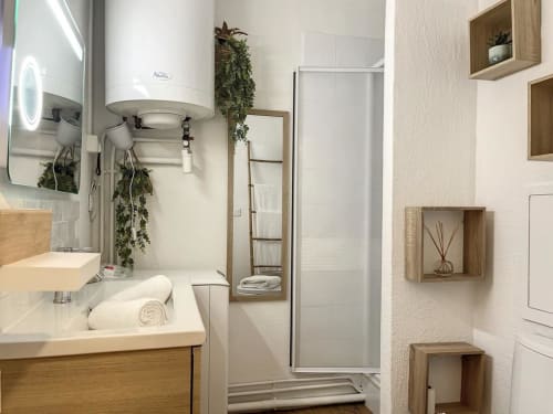 Salle de bain moderne du studio Les Suites Du Port à Arcachon, avec douche à l'italienne et meuble vasque en bois