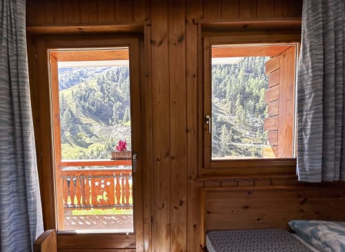 Vue alpine depuis le balcon en bois de la Chambre Triple à l'Hôtel les Bouquetins à Zinal, Suisse