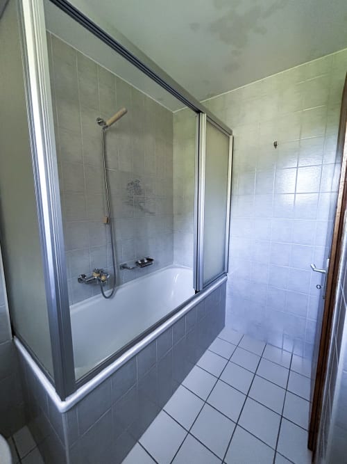 Salle de bain moderne à l'Hôtel les Bouquetins Zinal avec baignoire, douche à l'italienne et carrelage blanc