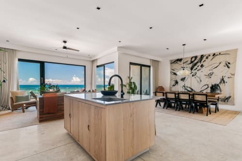Modern open-plan kitchen and dining area at Casa Copal, Isla Mujeres, with sea views and beachfront access