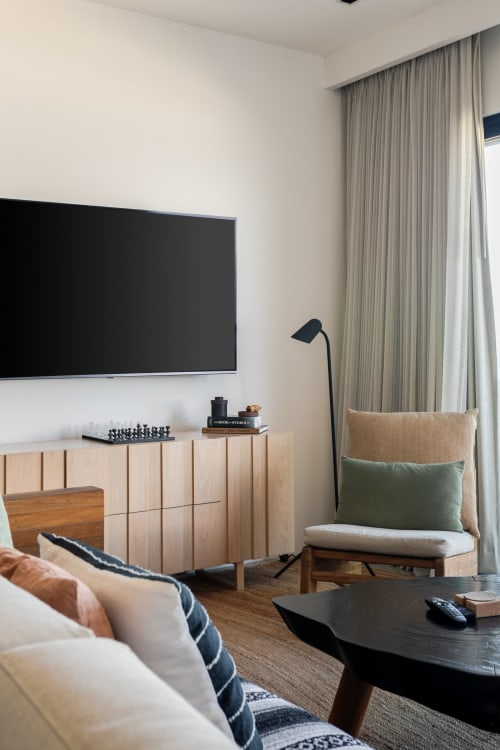 Modern living room in Casa Copal cottage at Isla Mujeres with flat-screen TV, wooden furniture, and sea-view terrace in