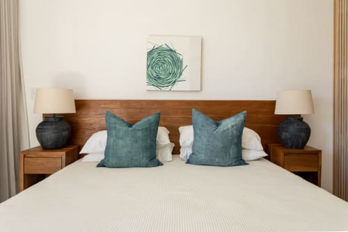 Bedroom in Casa Copal cottage, Isla Mujeres, with wood headboard, teal pillows, white bedding, and sea view artwork