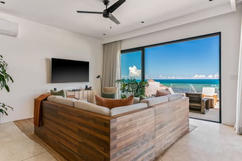 Modern beachfront living room at Casa Copal, Isla Mujeres, with ocean views through floor-to-ceiling windows