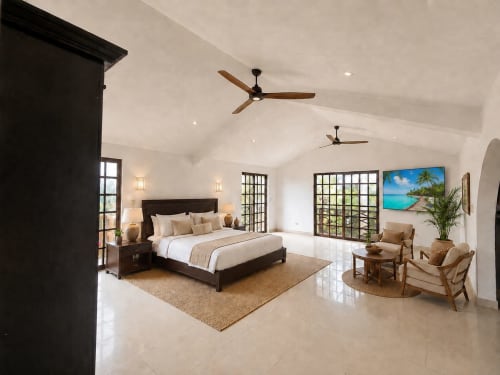 Spacious master bedroom with king bed, ceiling fans, and garden views at Hacienda las Golondrinas villa in Isla Mujeres