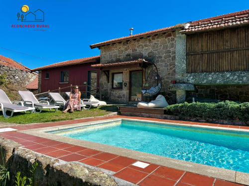Aconchego Rural cottage with private pool, lounge chairs, and stone architecture in Montalegre