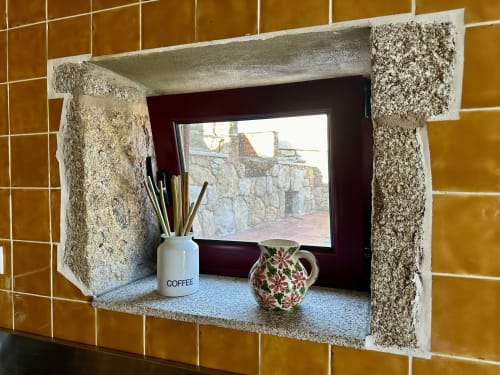 Mountain view window in rustic cottage with decorative tilework, coffee mug, and flowers at Aconchego Rural