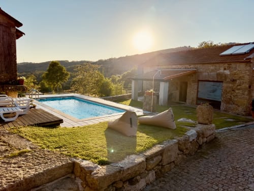 Aconchego Rural cottage with private pool, mountain views, and stone architecture at sunset in Montalegre