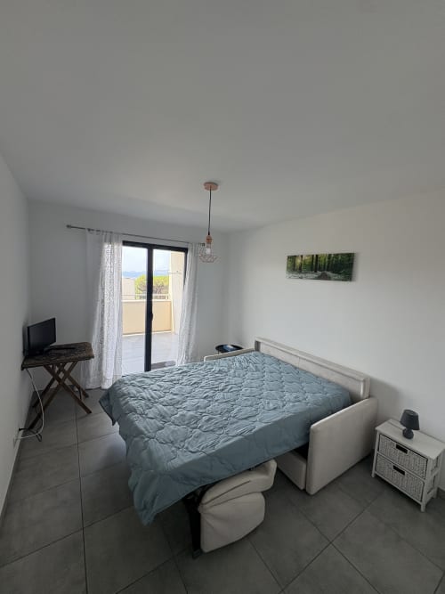 Chambre moderne dans un appartement à Porticcio avec vue sur mer, lit queen-size, TV, bureau et accès à la terrasse