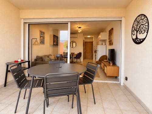Terrasse d'appartement à L'Île-Rousse avec table à manger, vue sur la ville et mobilier moderne
