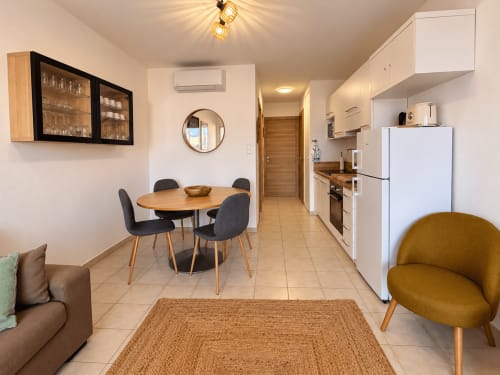 Appartement T2 moderne à L'Île-Rousse avec salle à manger, cuisine équipée, séjour et mobilier contemporain