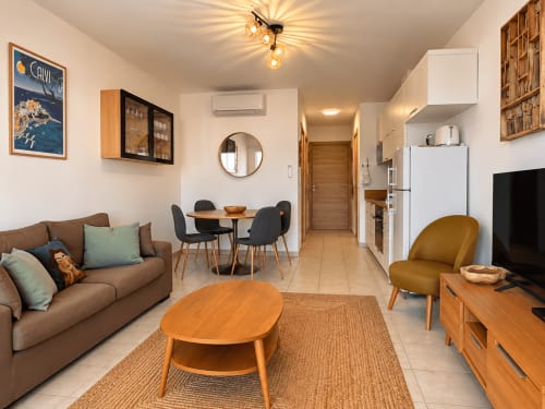 Séjour moderne à Calvi avec canapé marron, mobilier en bois et coin repas à L'Île-Rousse