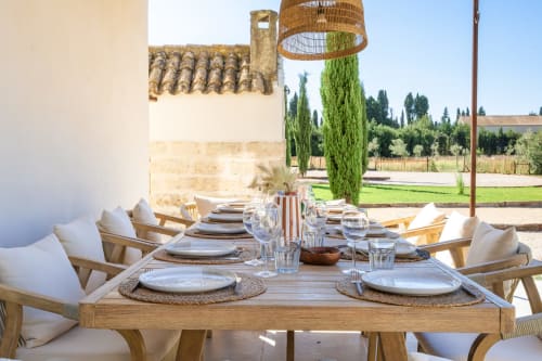 Élégante table dressée en plein air au Domaine Mas Lafleur à Châteaurenard avec chaises tressées et vue sur la campagne