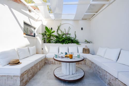 Lounge lumineux sur le toit de Domaine Mas Lafleur avec sièges blancs, plantes en pots et table ronde à Châteaurenard