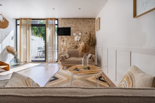 Salon moderne de la Villa Lafleur à Châteaurenard avec mobilier en bois, mur en liège et accès à la terrasse