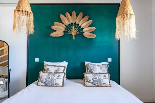 Chambre de la villa Lafleur au Domaine Mas Lafleur avec tête de lit bleu-vert, literie blanche et décor mural palmettes