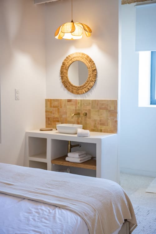 Salle de bain ensuite moderne au Domaine Mas Lafleur avec miroir tressé, vasque et luminaires suspendus chaleureux