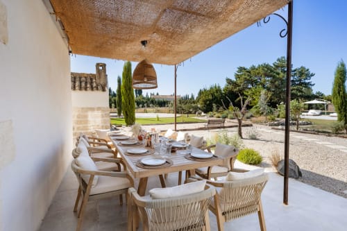 Terrasse de restauration extérieure au Domaine Mas Lafleur avec voile d'ombrage, table en bois et vue sur la campagne de Châteaurenard