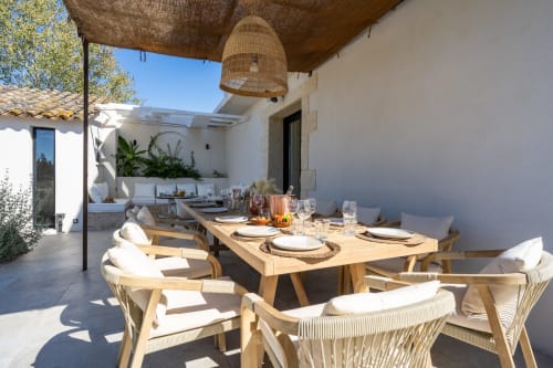 Terrasse de restaurant en plein air au Domaine Mas Lafleur avec table en bois, chaises tressées et parasol méditerranéen