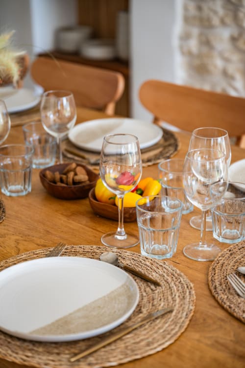 Table à manger élégamment dressée au Domaine Mas Lafleur avec assiettes blanches, verres à vin et citrons frais