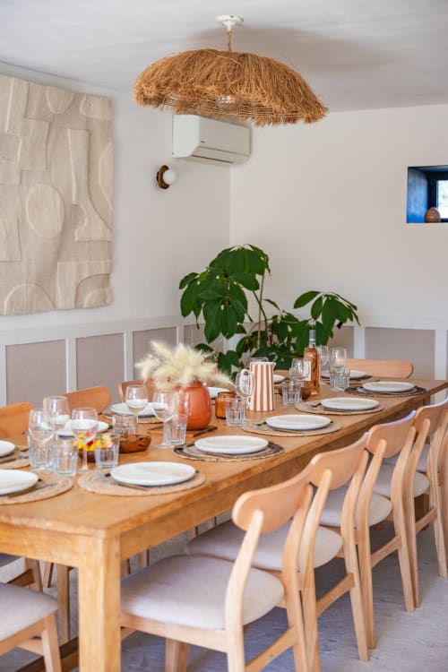 Salle à manger élégante du Domaine Mas Lafleur avec table en bois, chaises en bois clair et lustre tressé