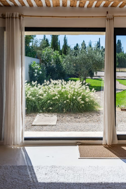 Vue de chambre Mas Lafleur donnant sur les jardins d'ornement, patio en gravier et cyprès à Châteaurenard
