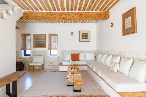 Séjour lumineux au Domaine Mas Lafleur à Châteaurenard avec poutres apparentes, canapé crème et décoration rustique