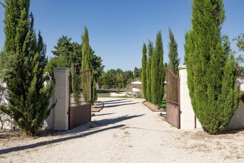 Portail d'entrée encadré de cyprès menant à Domaine Mas Lafleur B&B à Châteaurenard, France