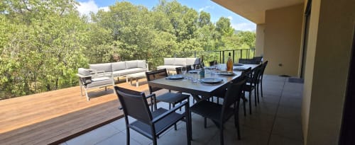 Vaste terrasse extérieure de la Villa Louniceli à Porto-Vecchio avec table à manger, salon de détente et vue sur les arbres