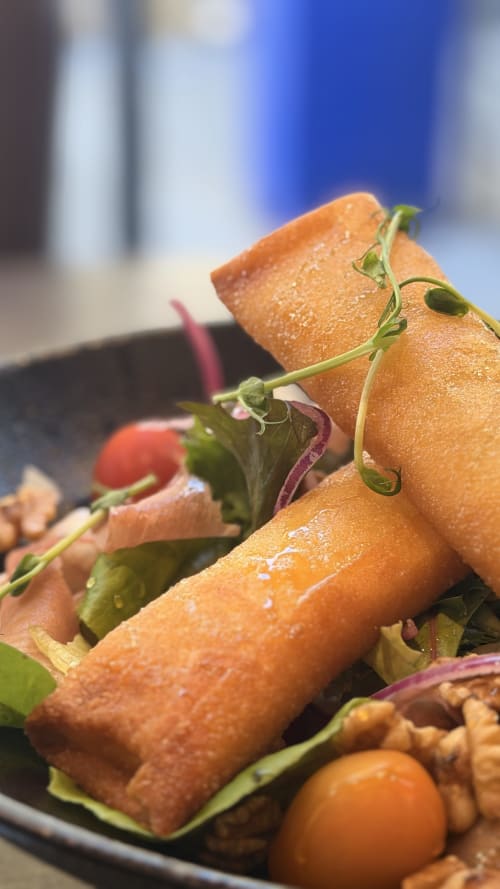 Plat gastronomique avec poisson poêlé, micropousses et tomates cerises à l'Hôtel Beau Rivage