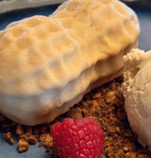 Boules de crème glacée à la vanille avec framboises fraîches et miettes de biscuit à l'Hôtel Beau Rivage, Alpes françaises.