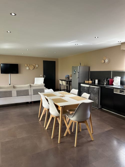Séjour et salle à manger ouverts et modernes à la Villa Maé des Villas d'A Storia, Corse, avec table en bois et chaises blanches,