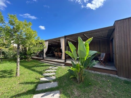 Villa contemporaine avec terrasse en bois, pergola ombragée, plantes tropicales et jardin aménagé aux Villas d'A Storia à Ghisonaccia