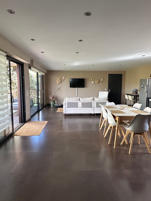 Séjour ouvert à Villa Maé avec table à manger, canapé blanc, téléviseur et accès au jardin aux Villas d'A Storia