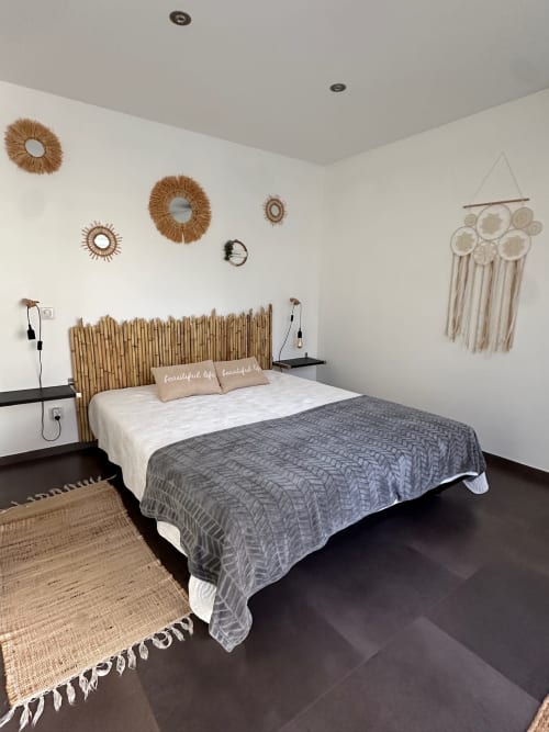 Chambre moderne à Villa Maé aux Villas d'A Storia, Ghisonaccia, avec tête de lit en bois, décoration murale tressée et sol foncé