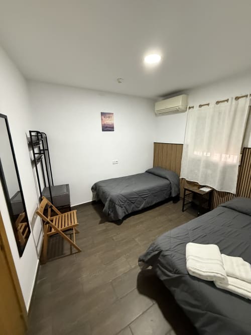 Amplia habitación doble en Hostal 3 hermanos de Getafe con dos camas, aire acondicionado, TV de pantalla plana y piso accesible