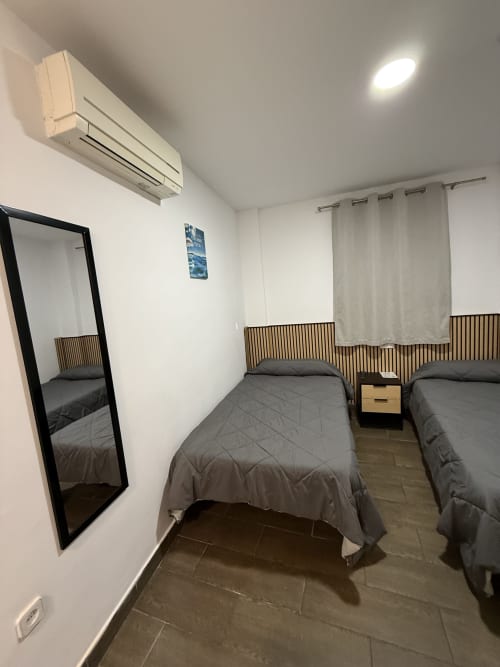 Luminosa habitación doble en Hostal3hermanos de Getafe con dos camas, aire acondicionado, espejo y piso de cerámica