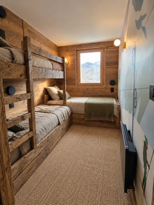Chambre cosy avec lits superposés en bois au Chalet du Vallon, La Plagne, vue montagne et stockage ski chauffé.