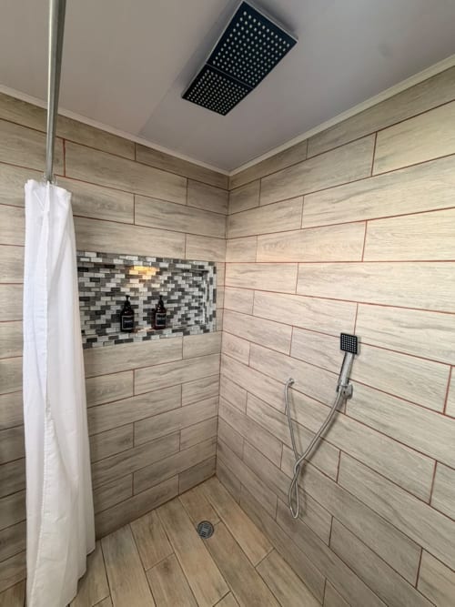 Baño moderno con azulejos de veta de madera, ducha de efecto lluvia y azulejos de mosaico decorativo en Chalets Vistas del Poas, Heredia